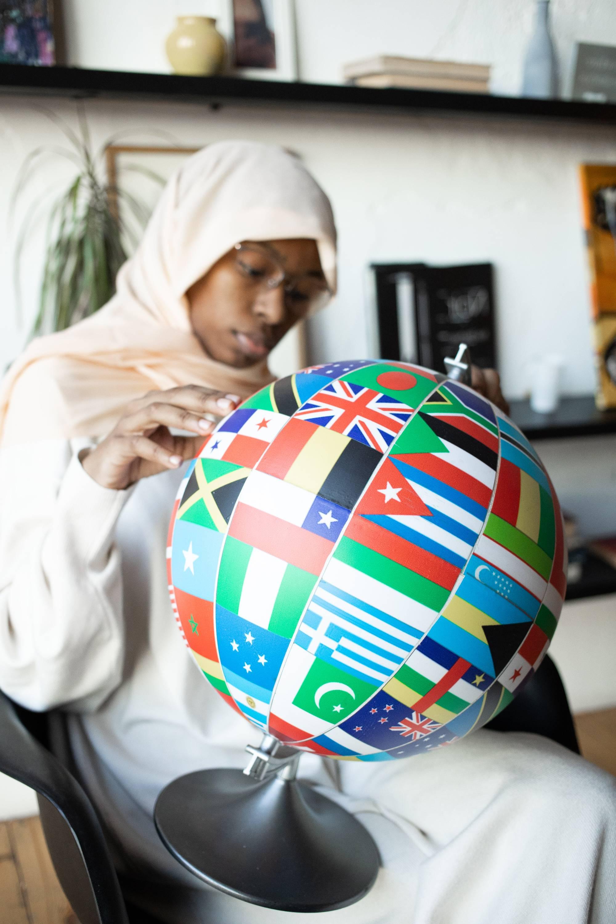 Person seated and looking at a globe.